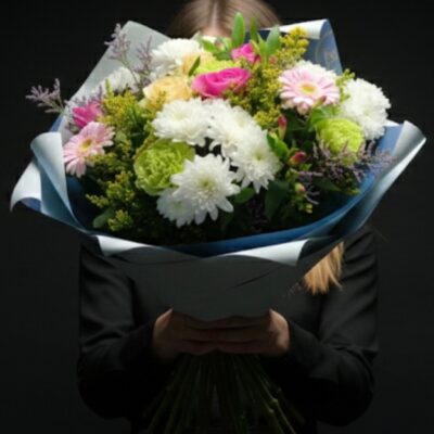 Bouquet "Jardin de Wervicq" ​Nom du produit : Bouquet Jardin de Wervicq Style : Naturel, champêtre et vaporeux Disponibilité : Roncq & Wervicq-Sud ​Description du produit ​Ce bouquet évoque la fraîcheur d'une promenade matinale dans nos jardins. Il combine des teintes douces de rose et de blanc avec des touches de vert acide pour un rendu plein de vitalité. L'habillage en papier de soie bleu ciel apporte une finition délicate qui souligne la légèreté des fleurs. ​Composition florale ​Roses "Sweet" : Un mélange de rose poudré et de crème pour le romantisme. ​Gerberas Pastels : Pour la rondeur et la gaieté. ​Chrysanthèmes de fleurs : Pour le volume blanc éclatant. ​Solidago & Limonium : Pour la structure sauvage et le côté "fleurette". ​Feuillage de nos terres : Eucalyptus et jeunes pousses vertes issus de notre micro-ferme. ​Conseils d'Expert Escapade Florale ​Vase : Choisissez un vase de hauteur moyenne pour bien maintenir la corolle. ​Entretien : Ajoutez un peu de sucre ou un conservateur dans l'eau pour prolonger l'éclat des roses et des gerberas. ​Fraîcheur : Éloignez le bouquet des courants d'air et de la lumière directe du soleil. ​Retrouvez-nous ​Escapade Florale - Roncq : 10 rue Jules Cornard. ​Escapade Florale by Sam - Wervicq-Sud : 51 rue Gabriel Péri.